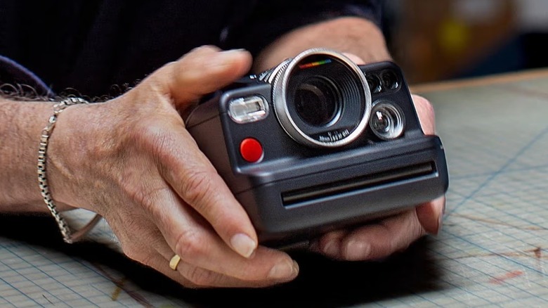 A person holding the black version of the Polaroid I-2