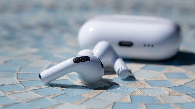 AirPods Pro 3 and their case on a blue glass square mosaic surface