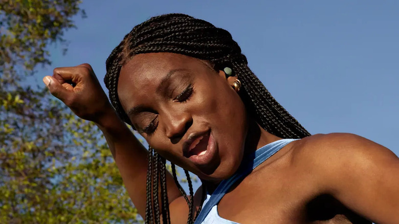 A woman dancing with Google Pixel Buds Pro 2 earbuds in her ears.