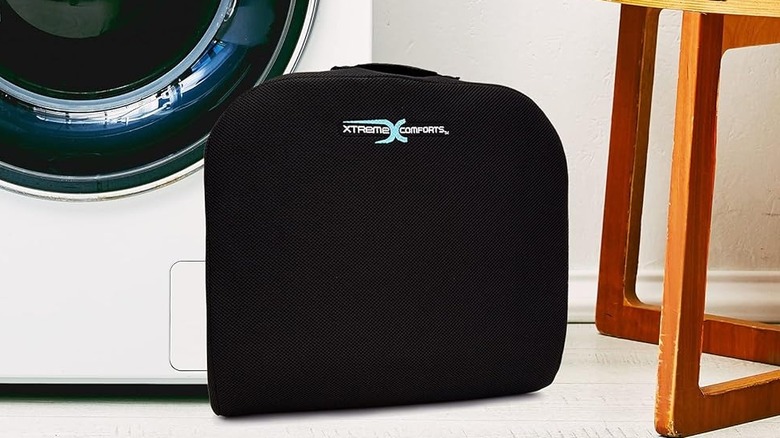 The Xtreme Comforts Large Seat Cushion on a white floor in front of a white washing machine.