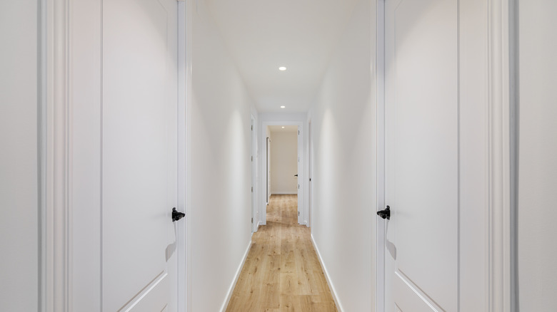 A narrow corridor with a few doors on either side.