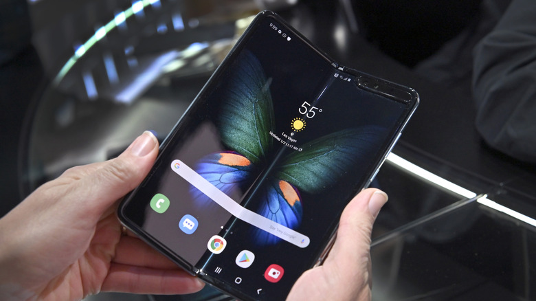 A person holding the first Samsung Galaxy Fold as it's partly unfolded and showing the crease.