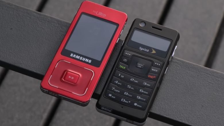 Two Samsung Galaxy UpStage phones, one in red and the other in black, on top of a railing.
