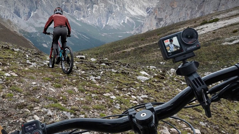 The DJI Osmo Action 4 action camera attached to the handlebars of a mountain bike.