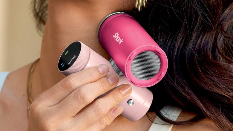 A person using the cooling plate of the Shark ChillPill handheld fan on her neck.