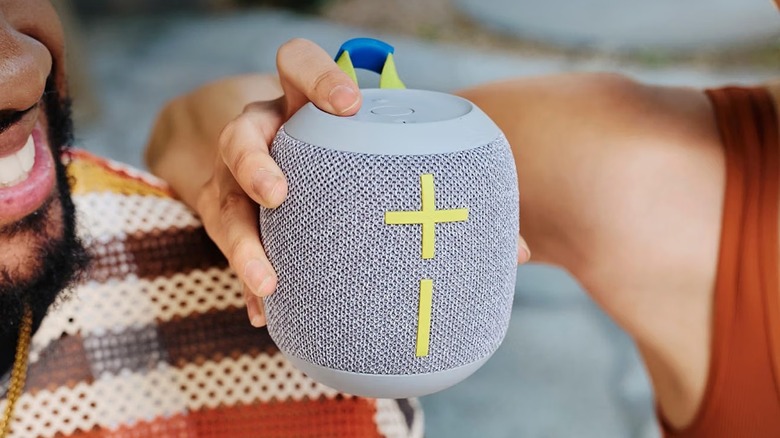 A person holding the Ultimate Ears Wonderboom 4 waterproof Bluetooth speaker.