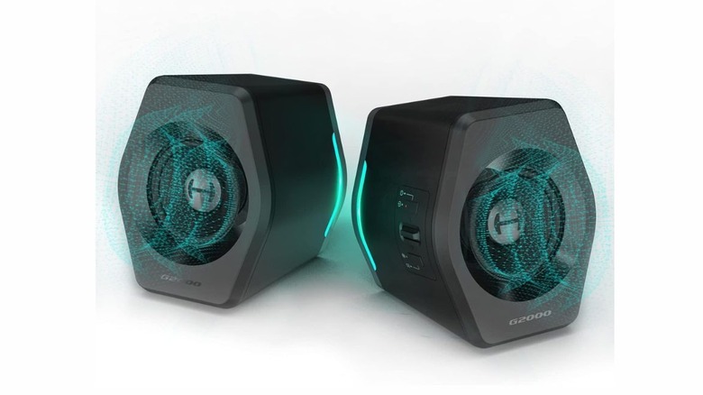 Two grayish black speakers with a hexagonal shape. There are circular blue lights coming out of each speaker to illustrate sound waves.