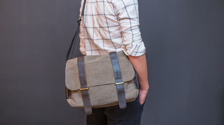 A person wearing a stylish messenger bag.