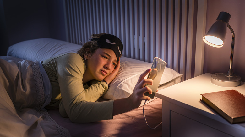 Person checking their phone at night in bed.