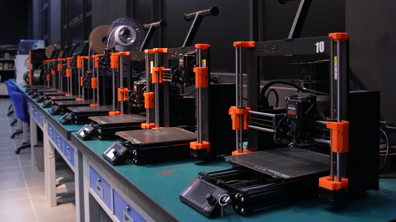 A row of professional Prusa bed-slinger FDM 3D printers.