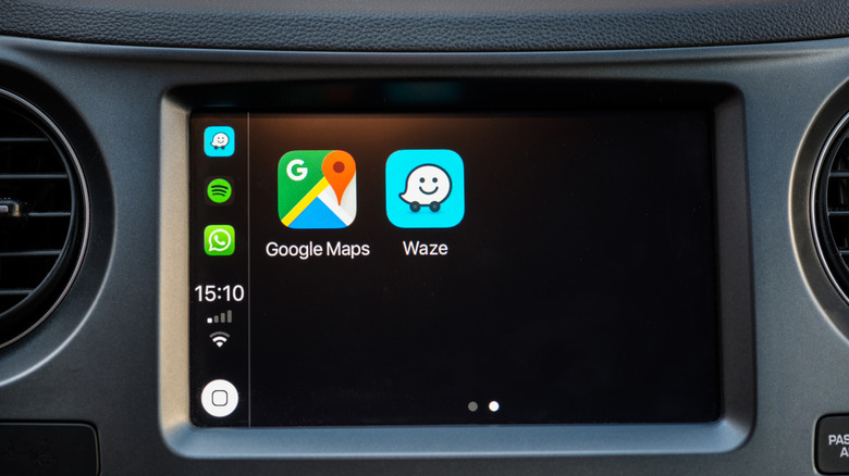 The Google Maps and Waze icons on the screen of a car's infotainment system.