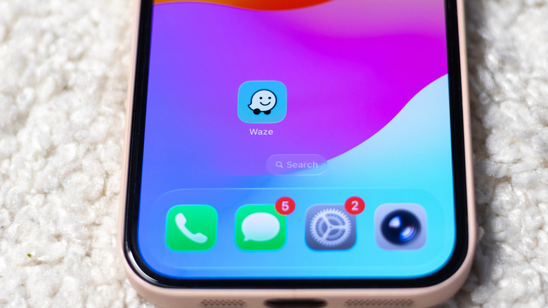 The Waze app icon on the screen of an iPhone.