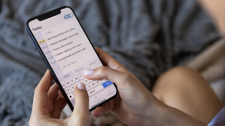 A person typing a routine into an iPhone.