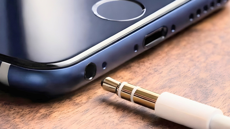 A headphone jack on a smartphone, with a plug being inserted.