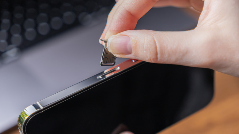Someone putting a SIM card into their phone.