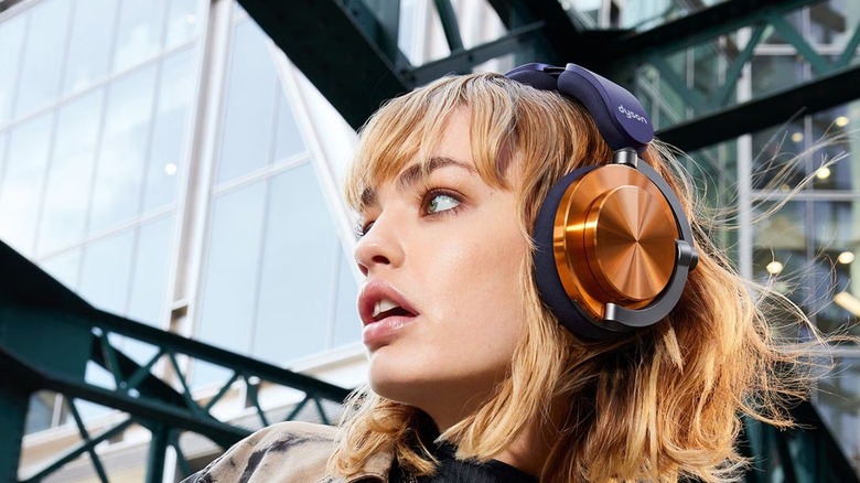 A woman wearing the Dyson OnTrac wireless headphones while outdoors.