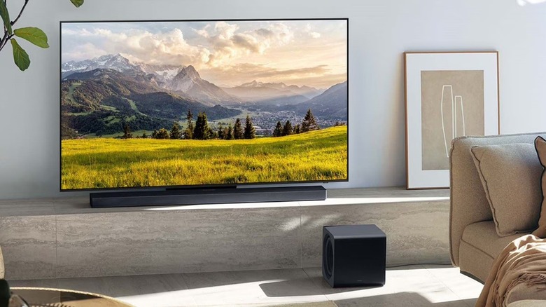 The Samsung HW-QS700F 3.1.2-channel soundbar, installed in a TV setup in a living room.