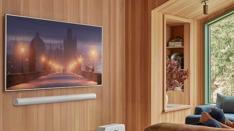 The Sonos Arc Ultra in white attached to a wall beneath a smart TV.