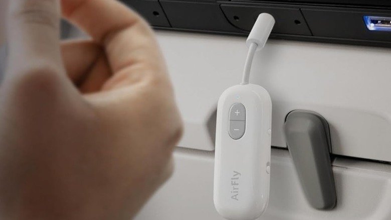 The Twelve South AirFly SE Bluetooth audio adapter plugged into an airplane's 3.5mm audio jack.