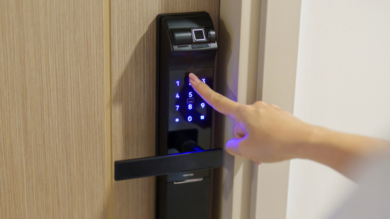 A smart lock that uses a pin, attached to a wooden door