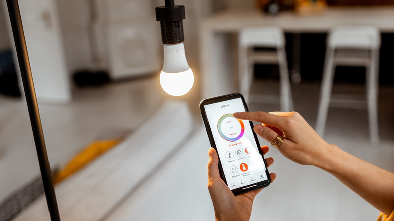 A person configuring the color of a smart light bulb