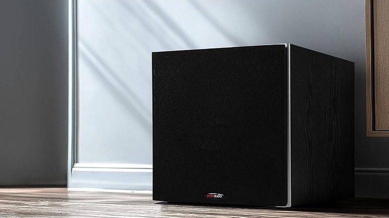 Polk Audio subwoofer placed along a wall on the floor.
