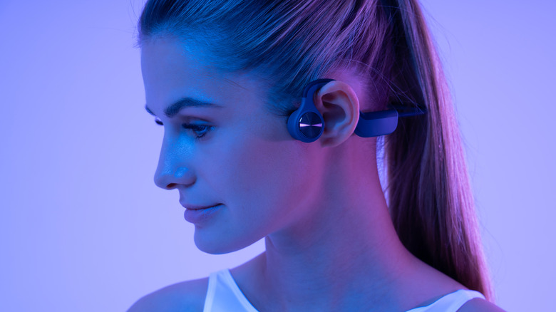 A woman wearing bone conduction headphones.