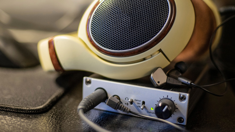 A pair of headphones on top of a dedicated headphone amp.