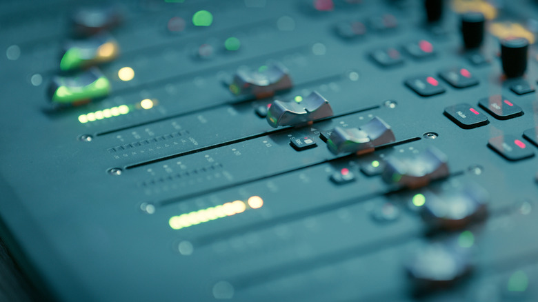 Audio faders on a studio mixing desk.
