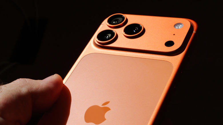 A close-up look of the camera module of the Apple iPhone 17 Pro Max in cosmic orange.