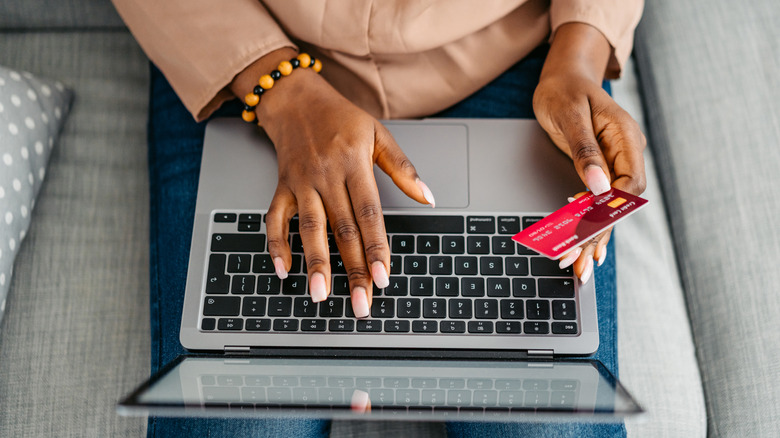 A person paying for online shopping on a laptop using a credit card.