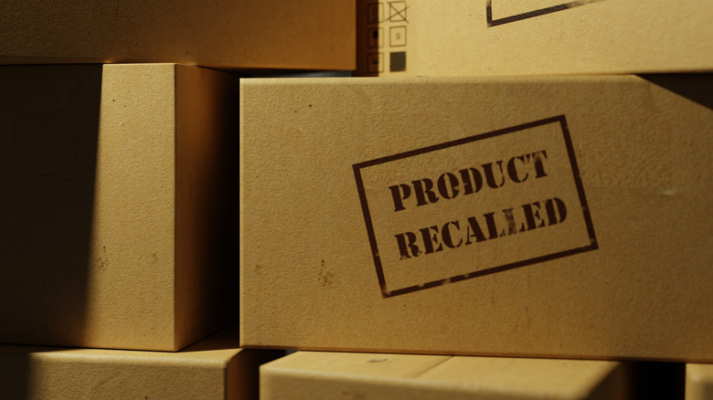 Boxes of recalled products stacked on top of each other, with a label on one side.