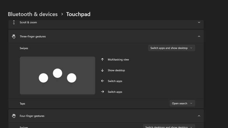 A screenshot showing Windows 11 settings. It shows the three-finger gestures sub-menu inside Touchpad settings, where the default option of switching apps and showing the desktop is selected