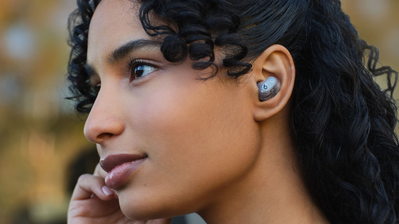 A person wearing the Beats Studio Buds +