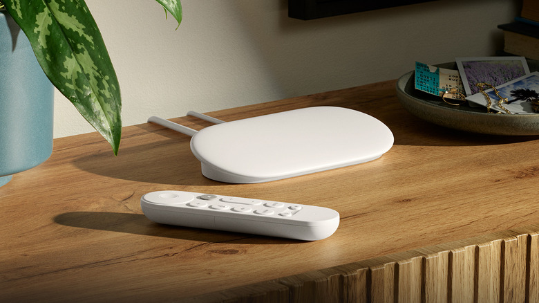 The Google TV Streamer on a wooden TV unit next to a plant