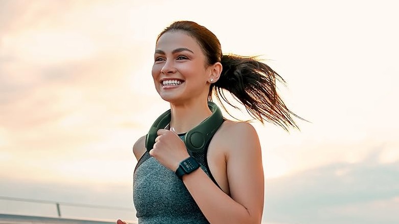 A woman is running while wearing a neck fan