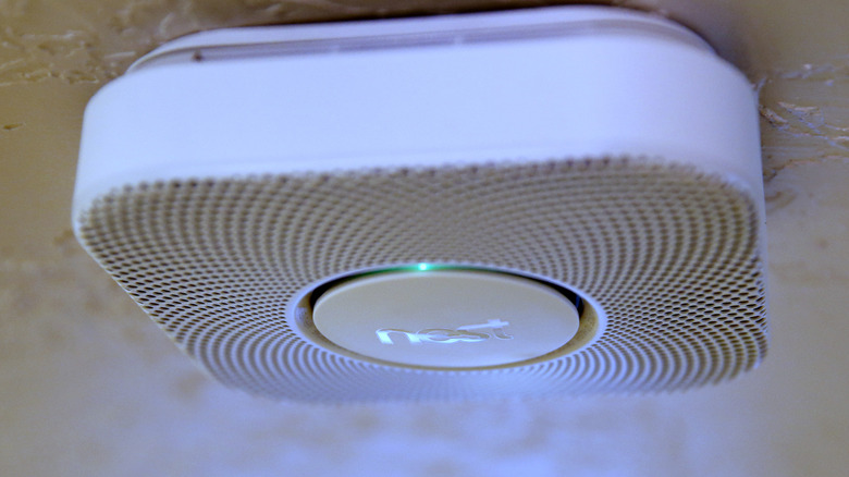 A Nest Protect smart smoke and carbon monoxide detector mounted on a ceiling.