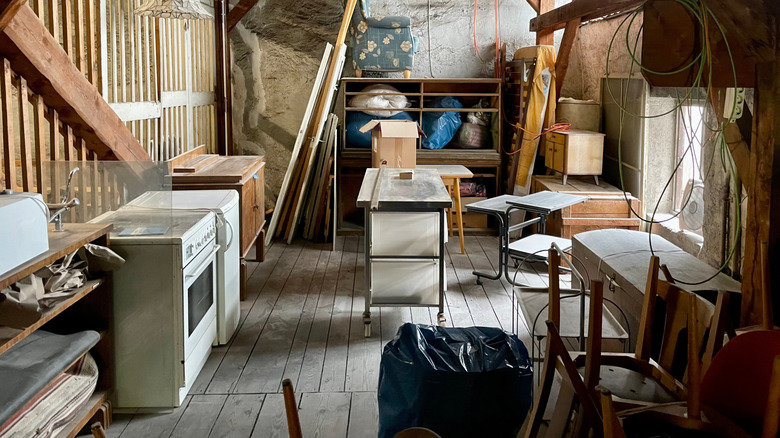 Cluttered attic or storage room filled with furniture, boxes, and household items.