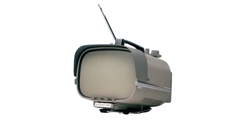 A compact vintage Sony portable television with a built-in carrying handle and extended telescopic antenna.