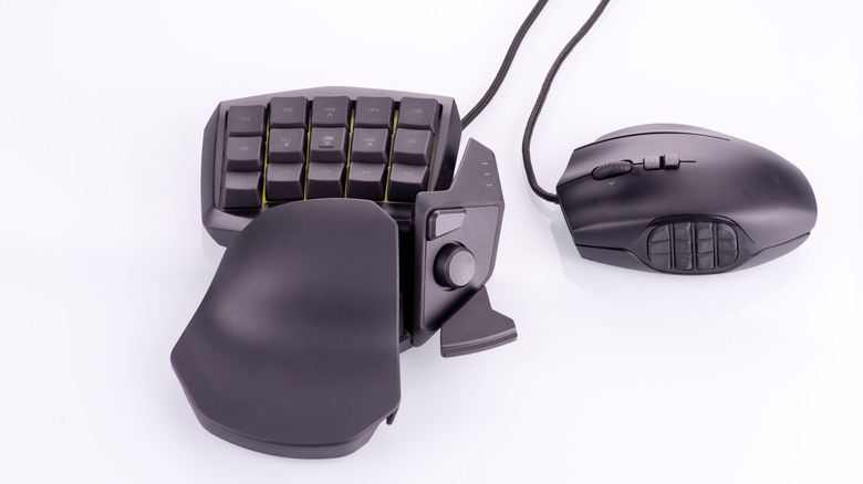 A gaming keypad and MMO-style mouse featuring programmable macro keys, an integrated thumbstick, and an ergonomic wrist rest for customizable game controls.