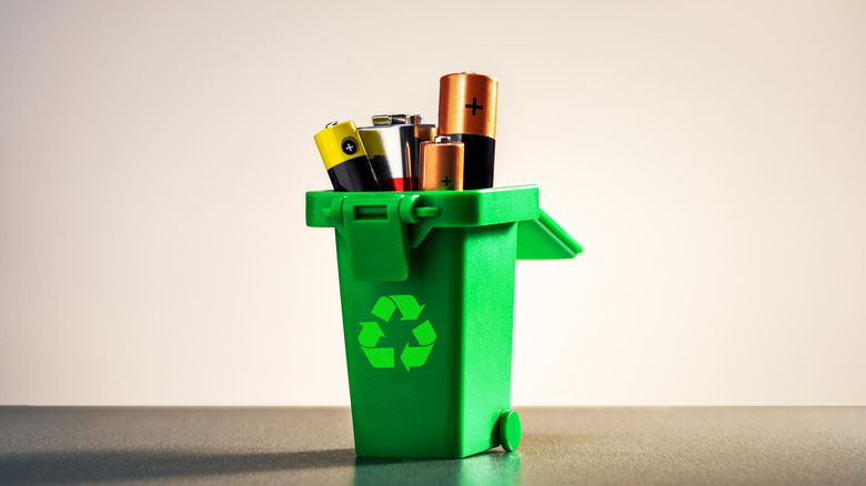 concept of recycling batteries in a green container