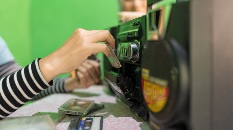 Putting a cassette tape into a vintage boombox