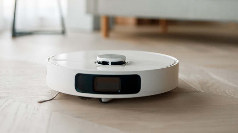 Robot vacuum cleaning hardwood floor in living room