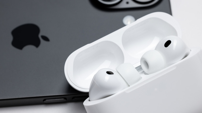 Pair of open Apple Airpods Pro 3 next to an iPhone 17