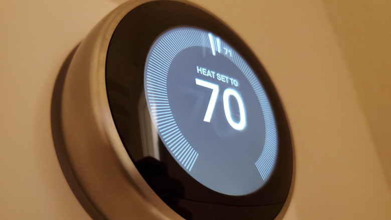 Smart thermostat on a wall showing heat set to 70 degrees