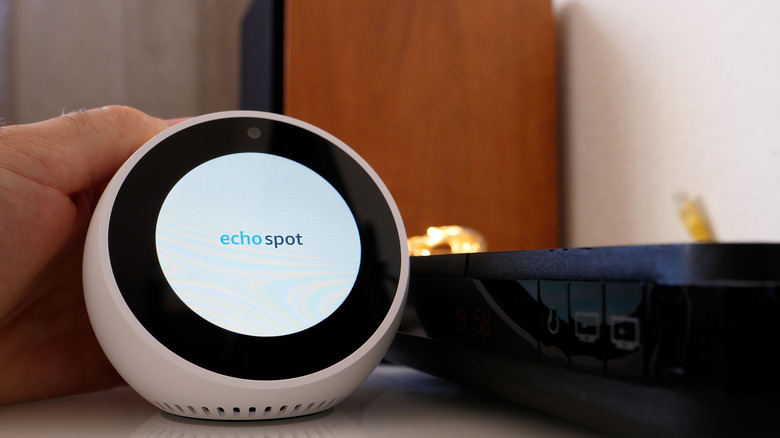 Hand holding an Echo Spot as it turns on