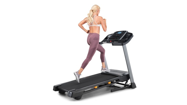 A woman on the NordicTrack T6.5S treadmill, on a white background.