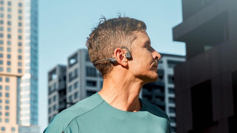 A person wearing the Shokz OpenRun Pro 2 bone conduction headphones while running outdoors.