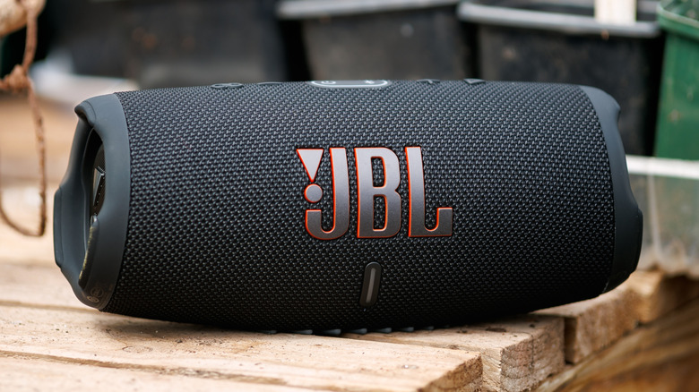 A black JBL speaker on a wooden table