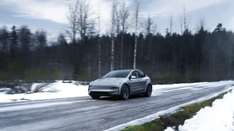 Gray Tesla Model Y in driving on a road in winter